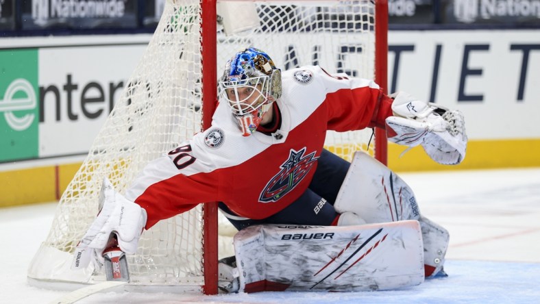 Feb 20, 2021; Columbus, Ohio, USA; Columbus Blue Jackets goaltender Elvis Merzlikins (90) reaches with his stick to defend the net against the Nashville Predators in the second period at Nationwide Arena. Mandatory Credit: Aaron Doster-USA TODAY Sports