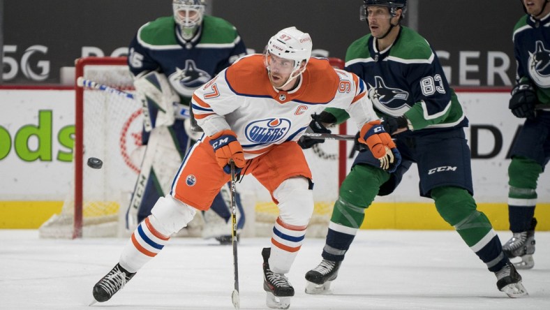 Feb 23, 2021; Vancouver, British Columbia, CAN; Edmonton Oilers forward Connor McDavid (97) skates after the loose puck against the Vancouver Canucks  in the second period at Rogers Arena. Mandatory Credit: Bob Frid-USA TODAY Sports