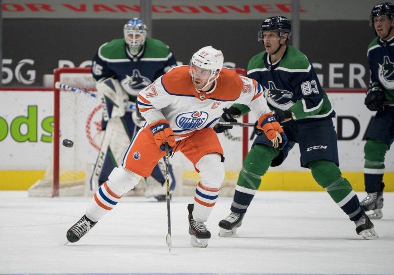Feb 23, 2021; Vancouver, British Columbia, CAN; Edmonton Oilers forward Connor McDavid (97) skates after the loose puck against the Vancouver Canucks  in the second period at Rogers Arena. Mandatory Credit: Bob Frid-USA TODAY Sports