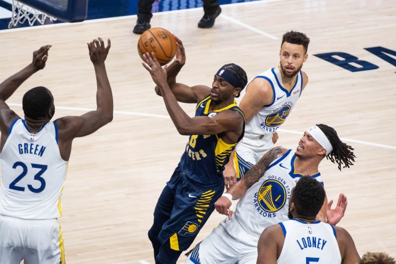 Feb 24, 2021; Indianapolis, Indiana, USA; Indiana Pacers guard Justin Holiday (8) passes the ball away from the Golden State Warriors defense in the second quarter at Bankers Life Fieldhouse. Mandatory Credit: Trevor Ruszkowski-USA TODAY Sports