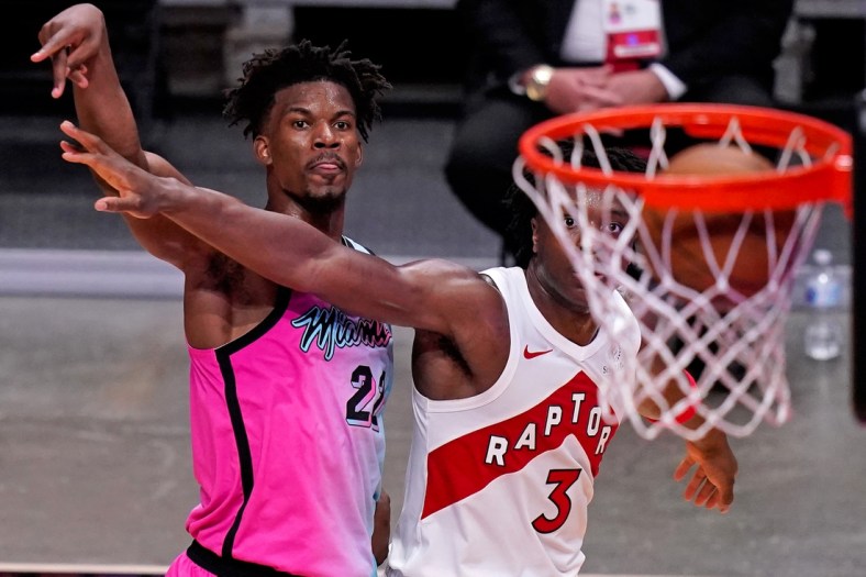 Feb 24, 2021; Miami, Florida, USA; Miami Heat forward Jimmy Butler (22) watches the ball into the net after shooting over Toronto Raptors forward OG Anunoby (3) during the second half at American Airlines Arena. Mandatory Credit: Jasen Vinlove-USA TODAY Sports