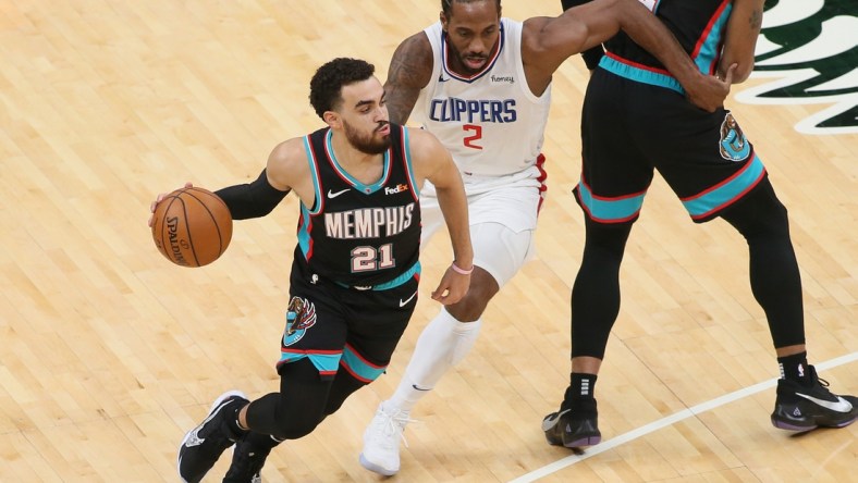 Feb 25, 2021; Memphis, Tennessee, USA; Memphis Grizzlies guard Tyus Jones (21) dribbles by Los Angeles Clippers forward Kawhi Leonard (2) during the first half at FedExForum. Memphis won 122-94. Mandatory Credit: Nelson Chenault-USA TODAY Sports