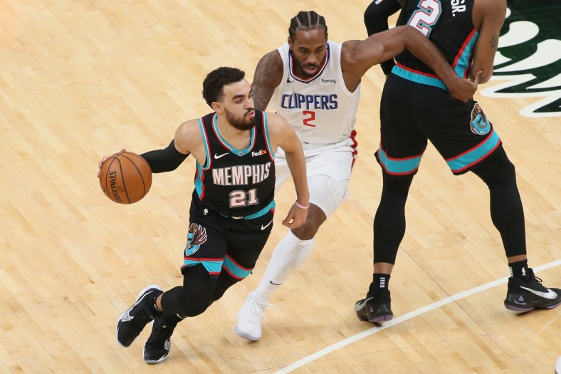 Feb 25, 2021; Memphis, Tennessee, USA; Memphis Grizzlies guard Tyus Jones (21) dribbles by Los Angeles Clippers forward Kawhi Leonard (2) during the first half at FedExForum. Memphis won 122-94. Mandatory Credit: Nelson Chenault-USA TODAY Sports