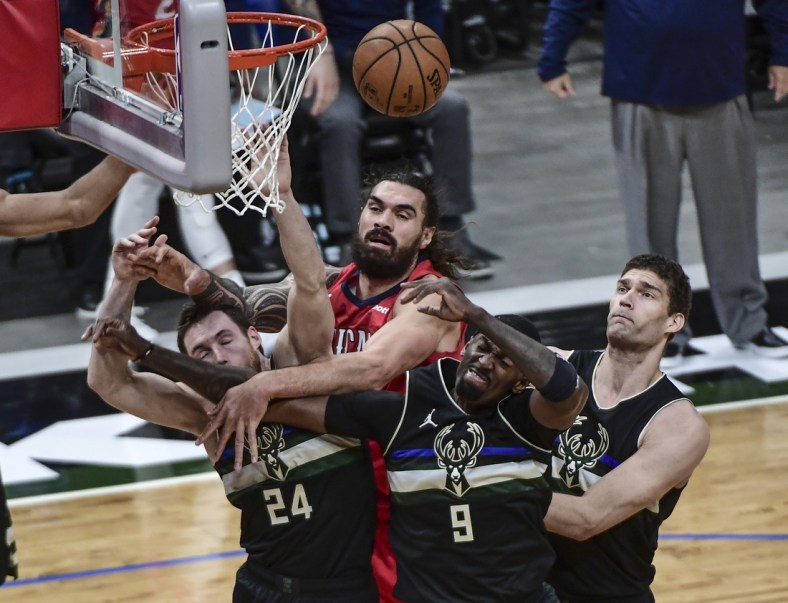 Feb 25, 2021; Milwaukee, Wisconsin, USA; New Orleans Pelicans center Steven Adams (top) battles for a rebound against Milwaukee Bucks guard Pat Connaughton (24) and center Bobby Portis (9) and center Brook Lopez (right) in the second quarter at Fiserv Forum. Mandatory Credit: Benny Sieu-USA TODAY Sports