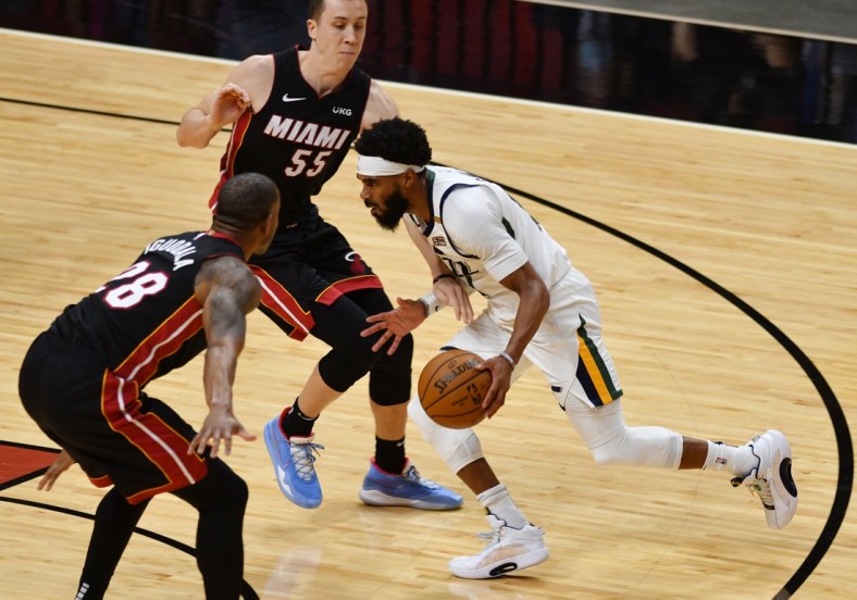 Feb 26, 2021; Miami, Florida, USA; Utah Jazz guard Mike Conley (10) splits the defense of Miami Heat guard Duncan Robinson (55) and forward Andre Iguodala (28) in the first quarter at American Airlines Arena. Mandatory Credit: Jim Rassol-USA TODAY Sports