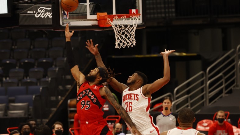 Feb 26, 2021; Tampa, Florida, USA;  Toronto Raptors forward DeAndre' Bembry (95) makes a basket as Houston Rockets center Justin Patton (26) fouls and shoots and one during the first half at Amalie Arena. Mandatory Credit: Kim Klement-USA TODAY Sports