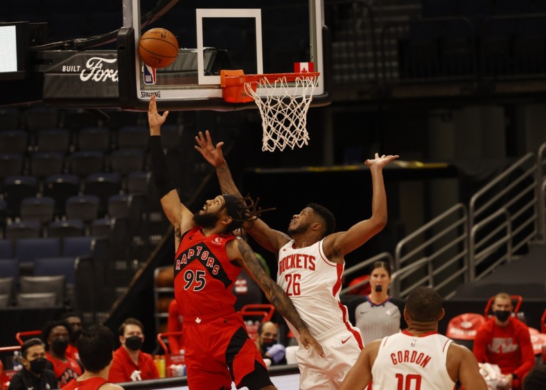 Feb 26, 2021; Tampa, Florida, USA;  Toronto Raptors forward DeAndre' Bembry (95) makes a basket as Houston Rockets center Justin Patton (26) fouls and shoots and one during the first half at Amalie Arena. Mandatory Credit: Kim Klement-USA TODAY Sports