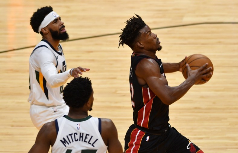Feb 26, 2021; Miami, Florida, USA; Miami Heat forward Jimmy Butler (22) drives to the basket past Utah Jazz guard Mike Conley (10) and guard Donovan Mitchell (45) in the second quarter at American Airlines Arena. Mandatory Credit: Jim Rassol-USA TODAY Sports