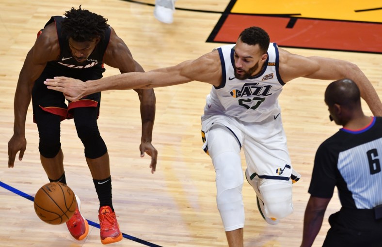 Feb 26, 2021; Miami, Florida, USA; Utah Jazz center Rudy Gobert (27) and Miami Heat forward Jimmy Butler (22) battle for a loose ball in the fourth quarter at American Airlines Arena. Mandatory Credit: Jim Rassol-USA TODAY Sports