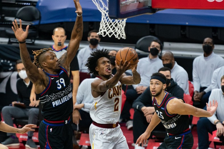 Feb 27, 2021; Philadelphia, Pennsylvania, USA; Cleveland Cavaliers guard Collin Sexton (2) drives for a score past Philadelphia 76ers center Dwight Howard (39) and guard Ben Simmons (25) during the second quarter at Wells Fargo Center. Mandatory Credit: Bill Streicher-USA TODAY Sports