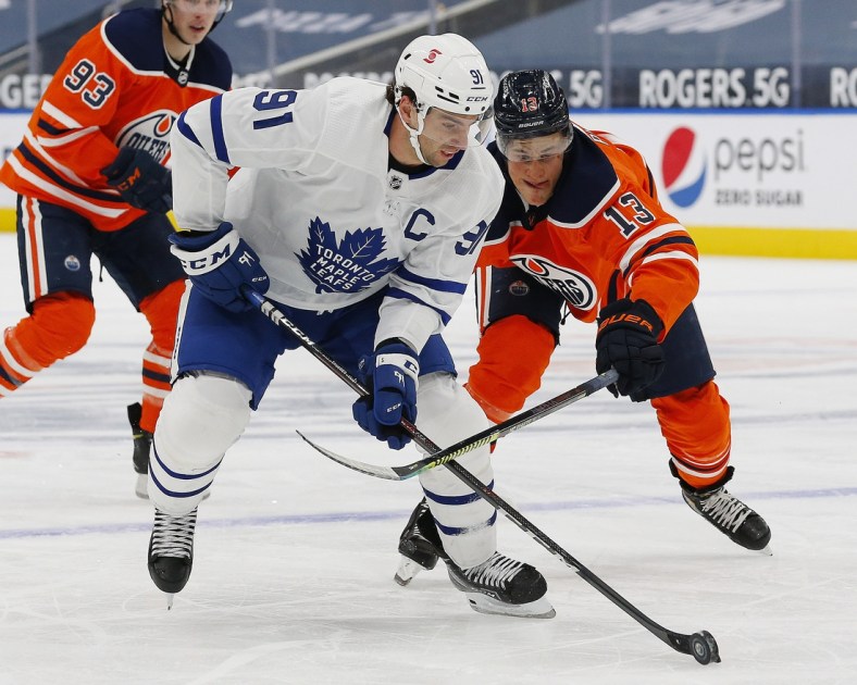 Feb 27, 2021; Edmonton, Alberta, CAN; Edmonton Oilers forward Jesse Puljujarvi (13) chases Toronto Maple Leafs forward John Tavares (91) during the second period at Rogers Place. Mandatory Credit: Perry Nelson-USA TODAY Sports