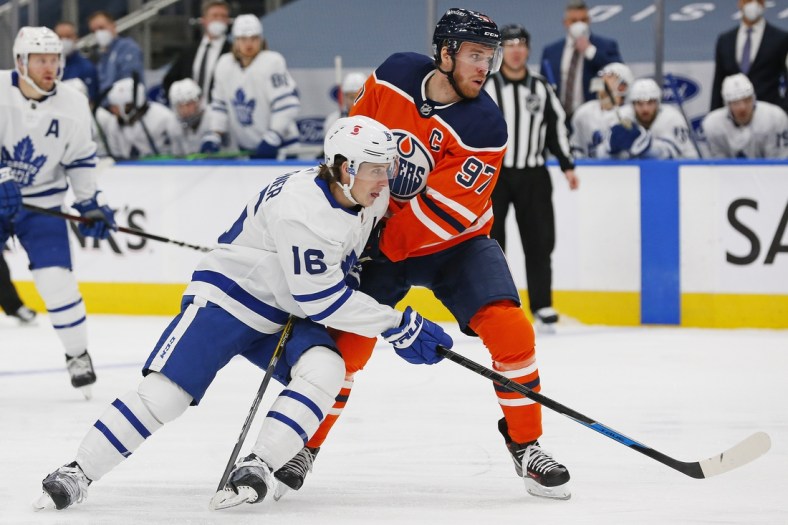 Feb 27, 2021; Edmonton, Alberta, CAN; Toronto Maple Leafs forward Mitch Marner (16) and Edmonton Oilers forward Connor McDavid (97) battle for position during the second period at Rogers Place. Mandatory Credit: Perry Nelson-USA TODAY Sports