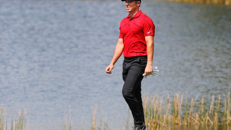 Feb 28, 2021; Bradenton, Florida, USA; Rory McIlroy walks to the second green wearing red and black honoring Tiger Woods during the final round of World Golf Championships at The Concession golf tournament at The Concession Golf Club. Mandatory Credit: Mike Watters-USA TODAY Sports