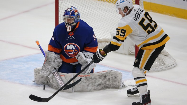 Feb 28, 2021; Uniondale, New York, USA; New York Islanders goalie Ilya Sorokin (30) makes a save against Pittsburgh Penguins left wing Jake Guentzel (59) during the second period at Nassau Veterans Memorial Coliseum. Mandatory Credit: Brad Penner-USA TODAY Sports