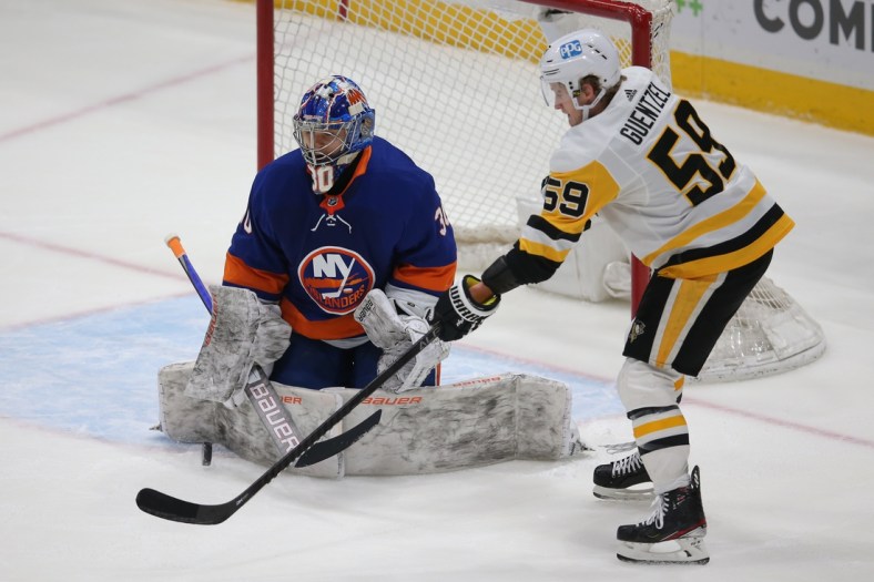 Feb 28, 2021; Uniondale, New York, USA; New York Islanders goalie Ilya Sorokin (30) makes a save against Pittsburgh Penguins left wing Jake Guentzel (59) during the second period at Nassau Veterans Memorial Coliseum. Mandatory Credit: Brad Penner-USA TODAY Sports