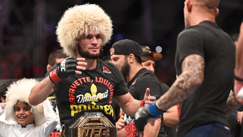 Sep 7, 2019; Abu Dhabi, UAE; Khabib Nurmagomedov (red gloves) greets Dustin Poirier (blue gloves) during UFC 242 at The Arena. Mandatory Credit: Per Haljestam-USA TODAY Sports