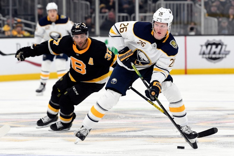 Dec 29, 2019; Boston, Massachusetts, USA; Buffalo Sabres defenseman Rasmus Dahlin (26) skates with the puck up ice in front of Boston Bruins center Patrice Bergeron (37) during the second period at the TD Garden. Mandatory Credit: Brian Fluharty-USA TODAY Sports
