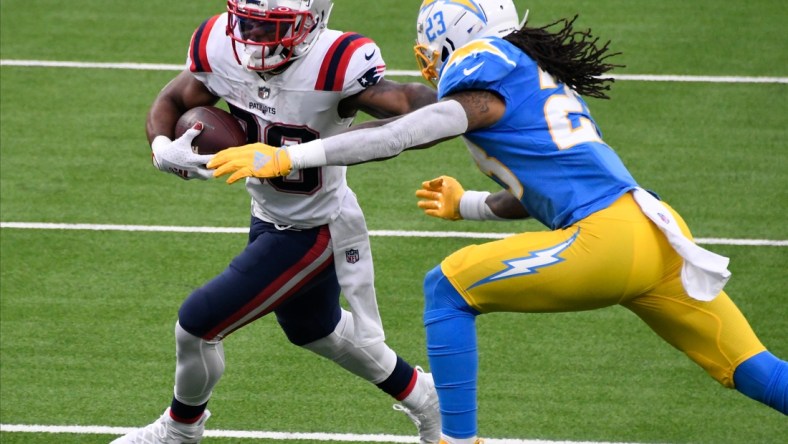 Dec 6, 2020; Inglewood, California, USA; New England Patriots running back James White (28) tries to break free from  Los Angeles Chargers free safety Nasir Adderley (24) during the second quarter at SoFi Stadium. Mandatory Credit: Robert Hanashiro-USA TODAY Sports