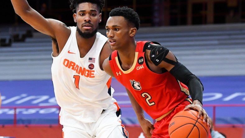 Dec 16, 2020; Syracuse, New York, USA; Northeastern Huskies guard Tyson Walker (2) drives to the basket against the defense of Syracuse Orange forward Quincy Guerrier (1) during the second half at the Carrier Dome. Mandatory Credit: Rich Barnes-USA TODAY Sports