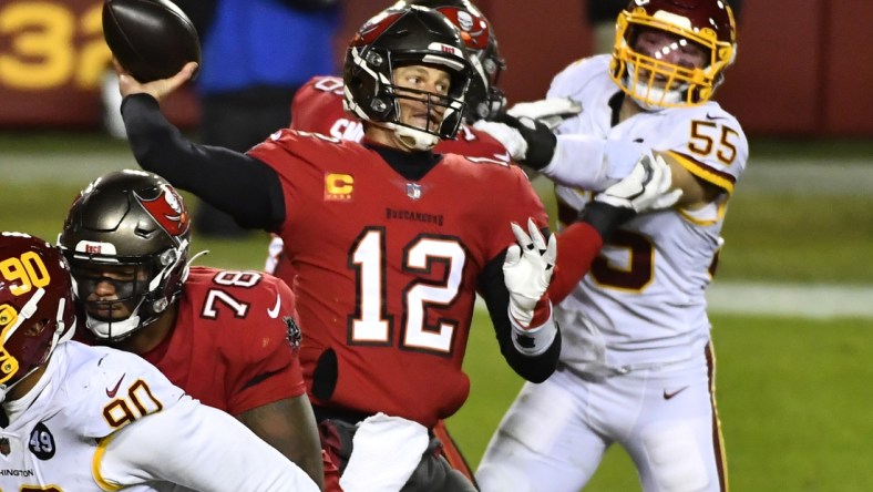 Jan 9, 2021; Landover, Maryland, USA; Tampa Bay Buccaneers quarterback Tom Brady (12) throws a pass as Washington Football Team linebacker Cole Holcomb (55) rushes during the third quarter at FedExField. Mandatory Credit: Brad Mills-USA TODAY Sports