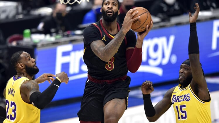 Jan 25, 2021; Cleveland, Ohio, USA; Cleveland Cavaliers center Andre Drummond (3) drives between Los Angeles Lakers forward LeBron James (23) and center Montrezl Harrell (15) in the first quarter at Rocket Mortgage FieldHouse. Mandatory Credit: David Richard-USA TODAY Sports