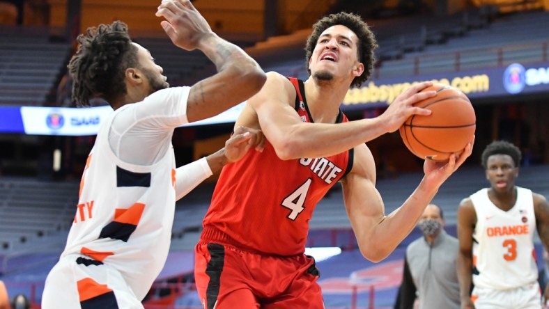 Jan 31, 2021; Syracuse, New York, USA; North Carolina State Wolfpack forward Jericole Hellems (4) looks to take a shot over the defense of Syracuse Orange forward Alan Griffin (0) in the second half at the Carrier Dome. Mandatory Credit: Mark Konezny-USA TODAY Sports