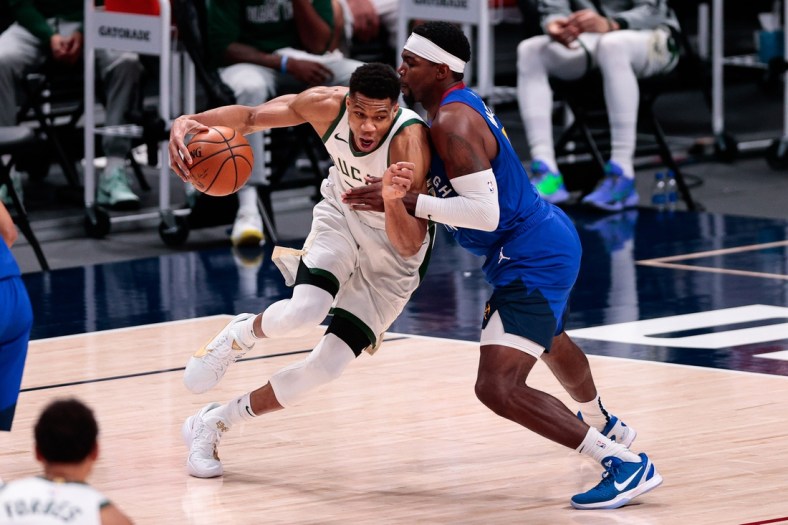Feb 8, 2021; Denver, Colorado, USA; Milwaukee Bucks forward Giannis Antetokounmpo (34) controls the ball as Denver Nuggets forward Paul Millsap (4) guards in the fourth quarter at Ball Arena. Mandatory Credit: Isaiah J. Downing-USA TODAY Sports
