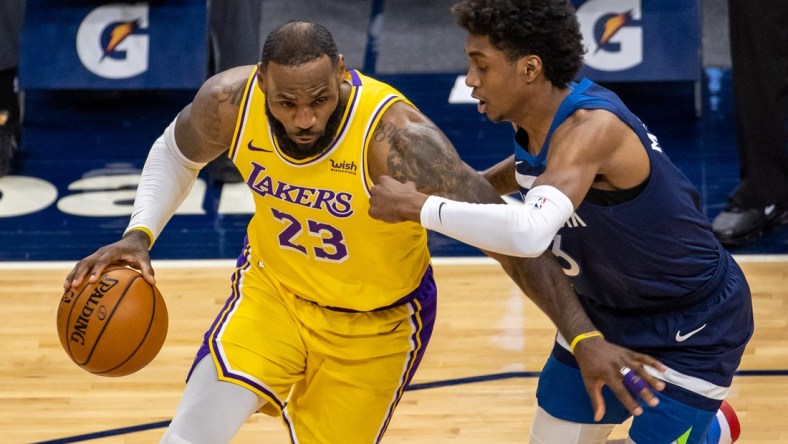 Feb 16, 2021; Minneapolis, Minnesota, USA; Los Angeles Lakers forward LeBron James (23) dribbles the ball against Minnesota Timberwolves forward Jaden McDaniels (3) in the second half at Target Center. Mandatory Credit: Jesse Johnson-USA TODAY Sports