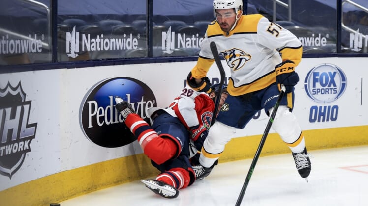 Feb 20, 2021; Columbus, Ohio, USA; Columbus Blue Jackets right wing Oliver Bjorkstrand (28) is checked by Nashville Predators defenseman Dante Fabbro (57) along the boards in the first period at Nationwide Arena. Mandatory Credit: Aaron Doster-USA TODAY Sports