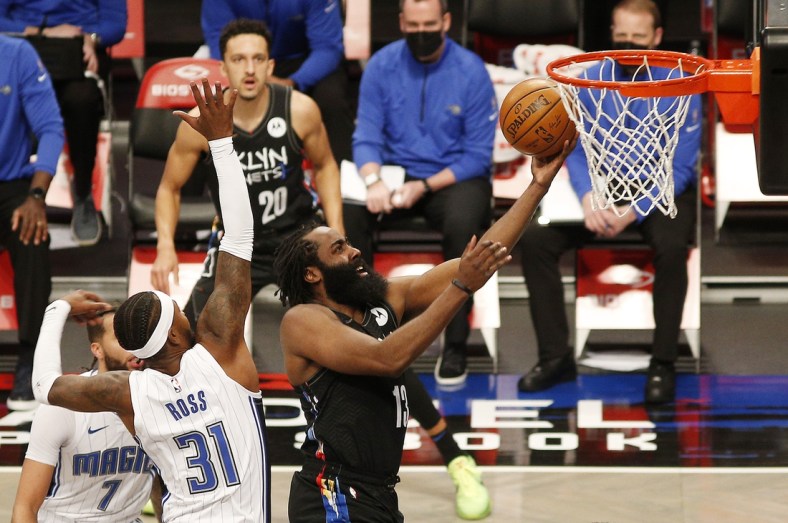 Feb 25, 2021; Brooklyn, New York, USA; Brooklyn Nets guard James Harden (13) lays the ball in the basket in front of Orlando Magic guard Terrence Ross (31) during the first half at Barclays Center. Mandatory Credit: Andy Marlin-USA TODAY Sports