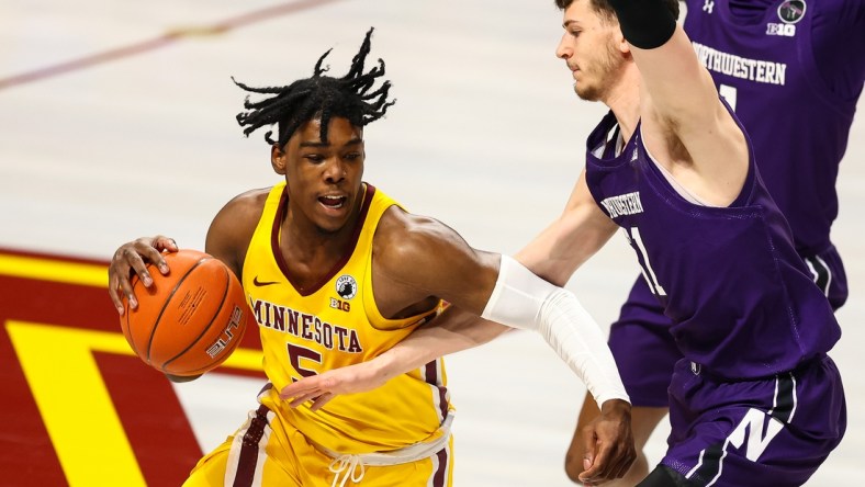 Feb 25, 2021; Minneapolis, Minnesota, USA; Minnesota Gophers guard Marcus Carr (5) drives to the basket as Northwestern Wildcats center Ryan Young (15) guards him during the first half at Williams Arena. Mandatory Credit: Harrison Barden-USA TODAY Sports