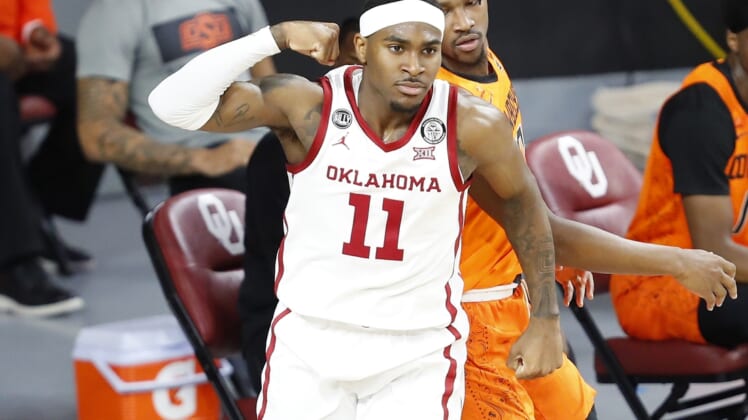 Feb 27, 2021; Norman, Oklahoma, USA; Oklahoma Sooners guard De'Vion Harmon (11) reacts after scoring against the Oklahoma State Cowboys during the first half at Lloyd Noble Center. Mandatory Credit: Alonzo Adams-USA TODAY Sports