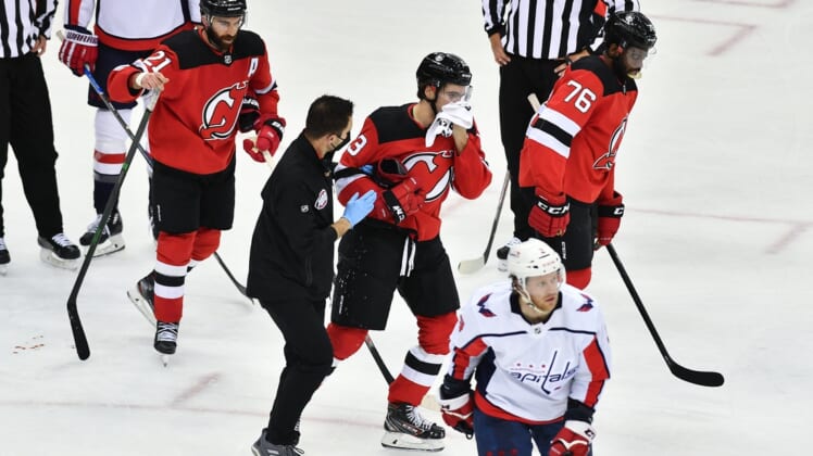 Feb 27, 2021; Newark, New Jersey, USA; New Jersey Devils center Nico Hischier (13) skates off the ice after being hit in the face during a game against the Washington Capitals during the third period at Prudential Center. Mandatory Credit: Catalina Fragoso-USA TODAY Sports