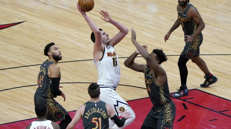 Mar 1, 2021; Chicago, Illinois, USA; Denver Nuggets center Nikola Jokic (15) shoots the ball over Chicago Bulls center Wendell Carter Jr. (34) during the fourth quarter at the United Center. Mandatory Credit: Mike Dinovo-USA TODAY Sports