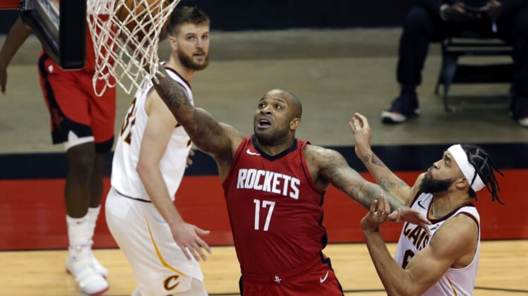 Mar 1, 2021; Houston, Texas, USA; Houston Rockets forward P.J. Tucker (17) puts up a shot between Cleveland Cavaliers forward Dean Wade (left) and center JaVale McGee (right) during the second half at the Toyota Center. Mandatory Credit:  Michael Wyke-POOL PHOTOS-USA TODAY Sports