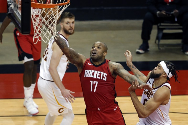 Mar 1, 2021; Houston, Texas, USA; Houston Rockets forward P.J. Tucker (17) puts up a shot between Cleveland Cavaliers forward Dean Wade (left) and center JaVale McGee (right) during the second half at the Toyota Center. Mandatory Credit:  Michael Wyke-POOL PHOTOS-USA TODAY Sports