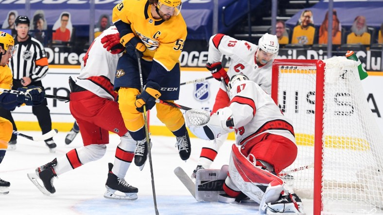 Mar 2, 2021; Nashville, Tennessee, USA; Nashville Predators defenseman Roman Josi (59) jumps after having a shot blocked by Carolina Hurricanes goaltender James Reimer (47) during the first period at Bridgestone Arena. Mandatory Credit: Christopher Hanewinckel-USA TODAY Sports