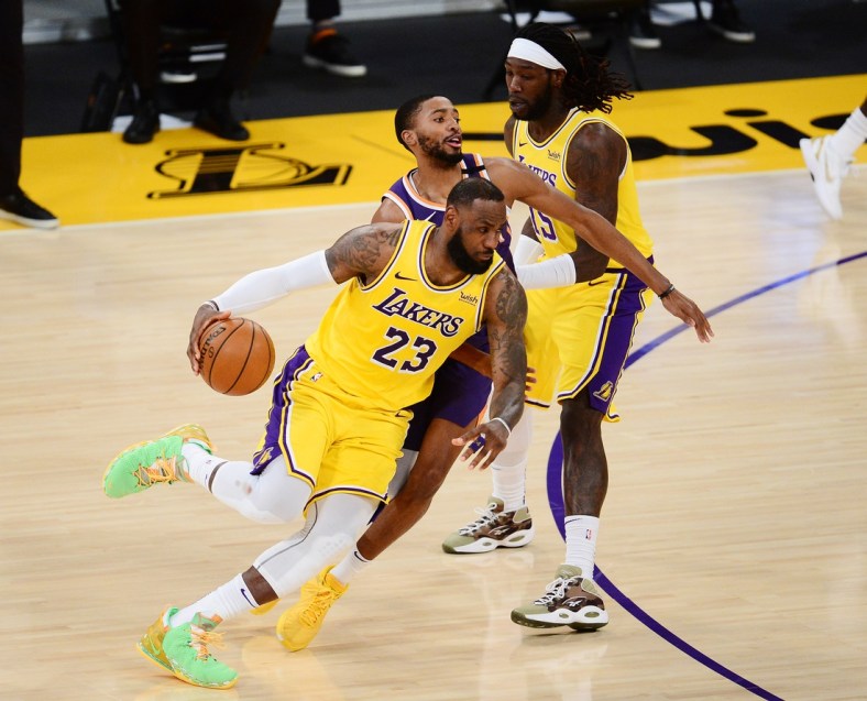 Mar 2, 2021; Los Angeles, California, USA; Los Angeles Lakers forward LeBron James (23) moves the ball as center Montrezl Harrell (15) provides coverage against Phoenix Suns forward Mikal Bridges (25) during the first half at Staples Center. Mandatory Credit: Gary A. Vasquez-USA TODAY Sports