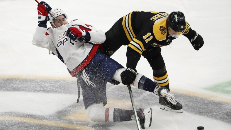 Mar 3, 2021; Boston, Massachusetts, USA; Boston Bruins center Trent Frederic (11) knocks down Washington Capitals right wing Tom Wilson (43) during the second period at TD Garden. Mandatory Credit: Winslow Townson-USA TODAY Sports