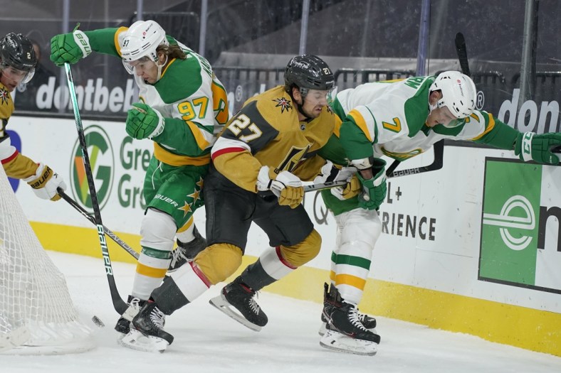 Mar 3, 2021; Las Vegas, Nevada, USA;  Minnesota Wild center Nico Sturm (7), Vegas Golden Knights defenseman Shea Theodore (27) and left wing Kirill Kaprizov (97) battle for the puck during the first period of an NHL hockey game Wednesday, March 3, 2021, in Las Vegas.  Mandatory Credit:  John Locher-POOL PHOTOS-USA TODAY Sports
