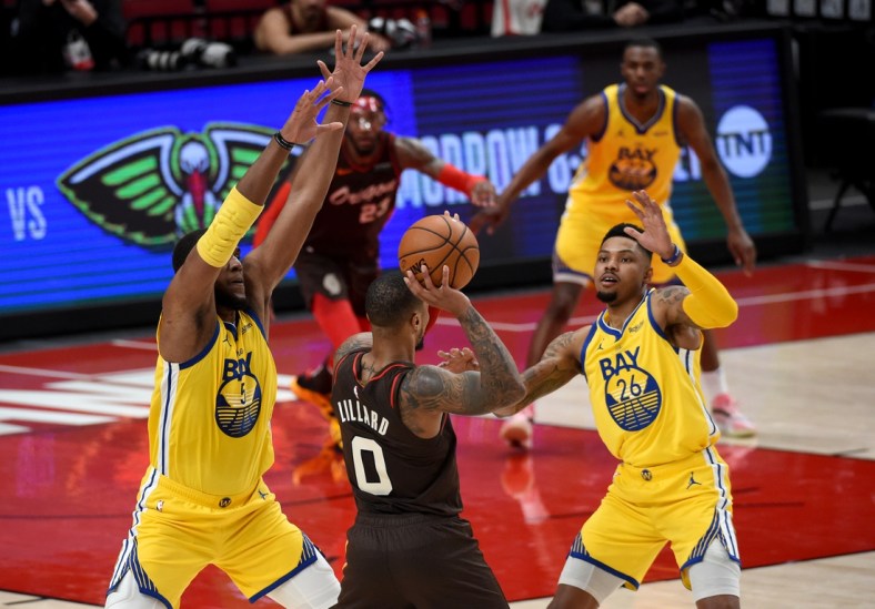 Mar 3, 2021; Portland, Oregon, USA; Golden State Warriors center Kevon Looney (5) and forward Kent Bazemore (26) defend Portland Trail Blazers guard Damian Lillard (0) during the first half at Moda Center. Mandatory Credit: Steve Dykes-USA TODAY Sports