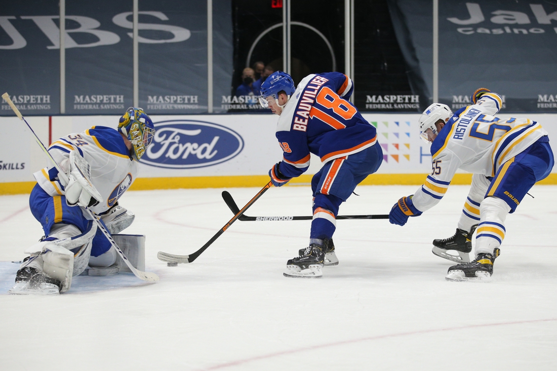 Mar 4, 2021; Uniondale, New York, USA; New York Islanders left wing Anthony Beauvillier (18) scores a goal against Buffalo Sabres goalie Jonas Johansson (34) in front of Sabres defenseman Rasmus Ristolainen (55) during the second period at Nassau Veterans Memorial Coliseum. Mandatory Credit: Brad Penner-USA TODAY Sports