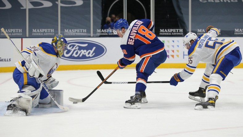 Mar 4, 2021; Uniondale, New York, USA; New York Islanders left wing Anthony Beauvillier (18) scores a goal against Buffalo Sabres goalie Jonas Johansson (34) in front of Sabres defenseman Rasmus Ristolainen (55) during the second period at Nassau Veterans Memorial Coliseum. Mandatory Credit: Brad Penner-USA TODAY Sports