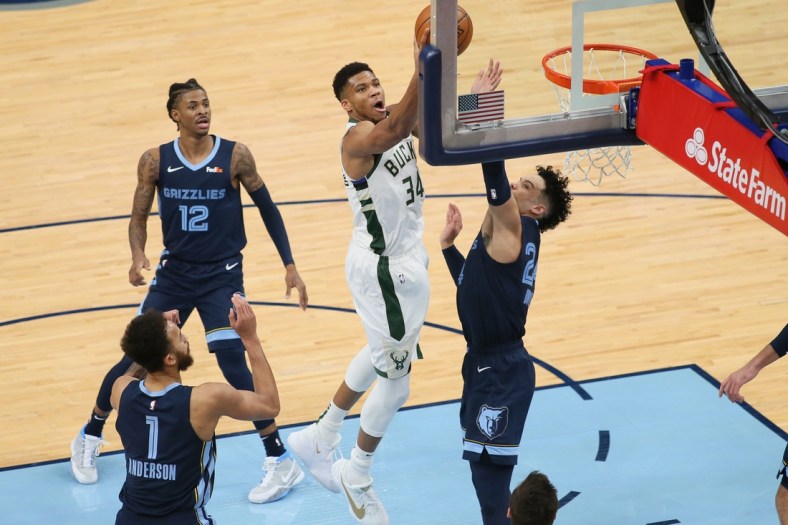 Mar 4, 2021; Memphis, Tennessee, USA; Milwaukee Bucks forward Giannis Antetokounmpo (34) shoots as Memphis Grizzlies  guard Dillon Brooks (24) defends while guard Ja Morant (12) looks on in the second quarter at FedExForum. Mandatory Credit: Nelson Chenault-USA TODAY Sports