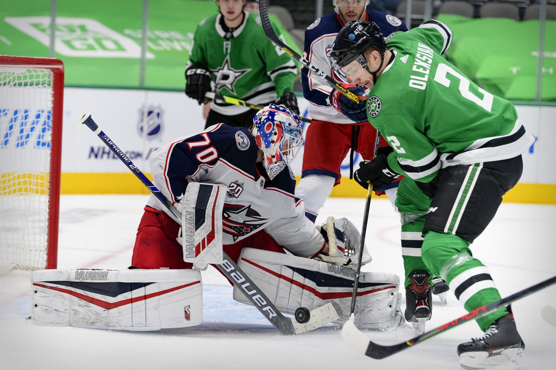 Mar 4, 2021; Dallas, Texas, USA; Columbus Blue Jackets goaltender Joonas Korpisalo (70) stops a shot by Dallas Stars defenseman Jamie Oleksiak (2) during the second period at the American Airlines Center. Mandatory Credit: Jerome Miron-USA TODAY Sports