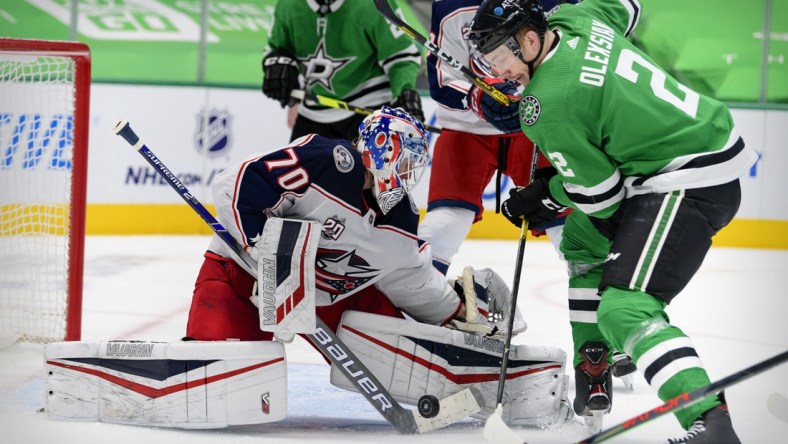 Mar 4, 2021; Dallas, Texas, USA; Columbus Blue Jackets goaltender Joonas Korpisalo (70) stops a shot by Dallas Stars defenseman Jamie Oleksiak (2) during the second period at the American Airlines Center. Mandatory Credit: Jerome Miron-USA TODAY Sports