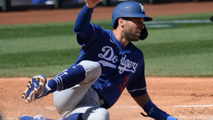 Mar 5, 2021; Surprise, Arizona, USA; Los Angeles Dodgers second baseman Chris Taylor (3) slides at home plate and scores a run against the Kansas City Royals during the second inning of a spring training game at Surprise Stadium. Mandatory Credit: Joe Camporeale-USA TODAY Sports