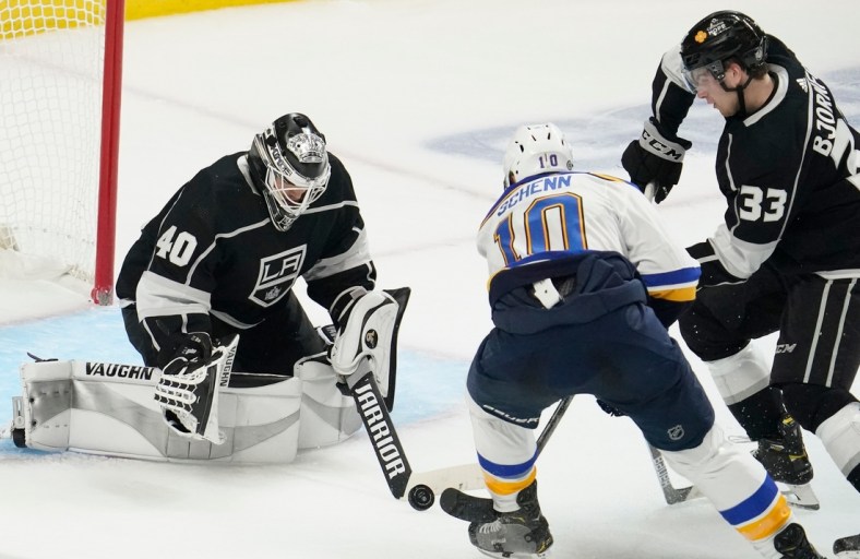 Mar 5, 2021; Los Angeles, California, USA; Los Angeles Kings goaltender Calvin Petersen (40) knocks the puck away from St. Louis Blues center Brayden Schenn (10) during the second period at Staples Center. At right is Los Angeles Kings defenseman Tobias Bjornfot (33). Mandatory Credit: Robert Hanashiro-USA TODAY Sports