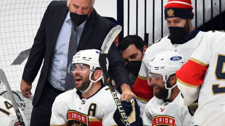 Mar 6, 2021; Nashville, Tennessee, USA; Florida Panthers defenseman Aaron Ekblad (5) is congratulated by head coach Joel Quenneville (top, left) after a first period goal against the Nashville Predators at Bridgestone Arena. Mandatory Credit: Christopher Hanewinckel-USA TODAY Sports