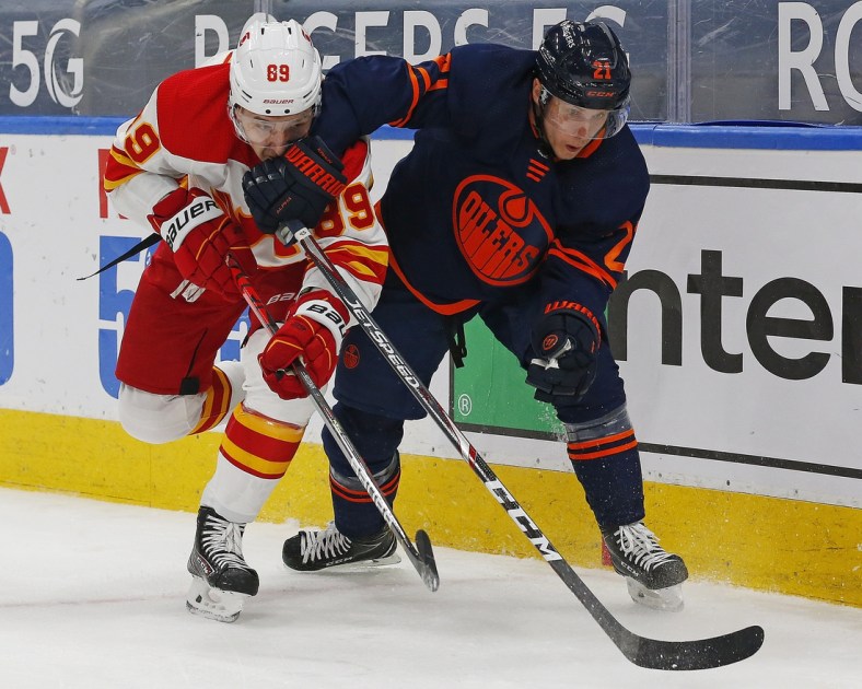 Mar 6, 2021; Edmonton, Alberta, CAN; Edmonton Oilers forward Dominik Kahun (21) and Calgary Flames defensemen Nikita Nesterov (89) battle for position during the first period at Rogers Place. Mandatory Credit: Perry Nelson-USA TODAY Sports